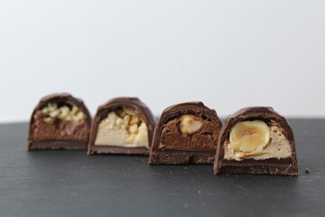 four chocolate case candies with hazelnuts peanut praline chocolate close-up on a gray background with space for copyspace text