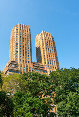 Obraz premium Towering towers of the Majestic apartments above the green trees of Manhattan's central park