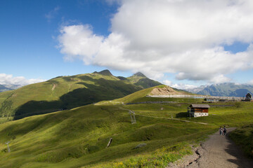 Alpine mountain landscape in Swiss Alps. Couple walking on mountain path