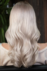 Naklejka premium Young woman in a hairdressing salon dyes her hair blond
