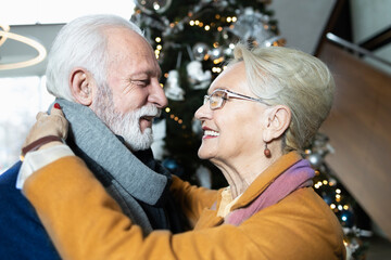 Close up of an elderly couple falling in love again by the Christmas tree