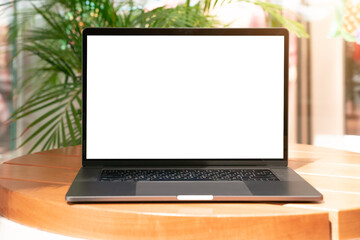 Laptop with white screen in vacation situation. Empty copy space, blank screen mockup. Soft focus laptop with interor background. Vacation, treveling and remote work concept