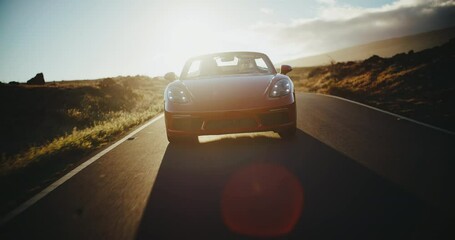 Red sports car driving on desert road, exhilarating sunset drive