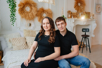 pregnant woman and man. a couple hugging on the bed.