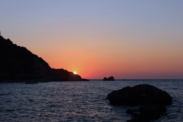 sunset over the sea with shore cliff 