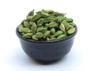 Green cardamom in a bowl on white background 