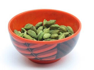 Green cardamom in a bowl on white background 