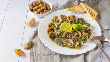 Patella, Limpets with lime on white plate - traditional seafood of Tenerife and Madeira Islands.