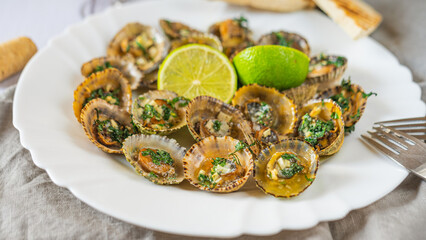 Patella, Limpets with lime on white plate - traditional seafood of Tenerife and Madeira Islands.