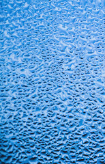 Texture of misted glass in autumn. Drops of water on window in rainy weather. Abstract background. Vertical photo.