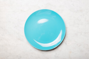 Empty blue plate on a light marble background