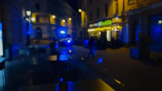 Defocused and dark: Emergency ambulance vehicle with flashing siren lights