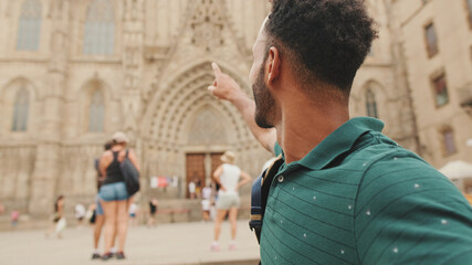 Close-up of young man tourist with backpack on his shoulder taking selfie on the Sagrada Família...