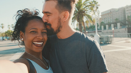 Close-up of interracial smiling couple in love taking selfie