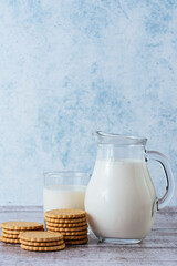 milk in a decanter and a glass with cookies