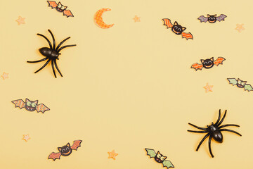 Halloween festive background with spiders and bats on yellow. Top view, flat lay, copy space