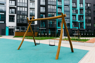 Fototapeta na wymiar children's swing in a modern courtyard of a residential area