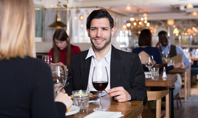 Portrait of couple who is dining and drinking wine in luxurious restaurant.