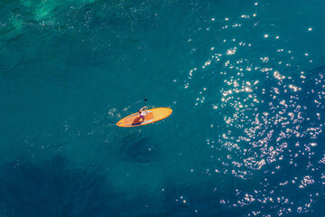 Young women Having Fun Stand Up Paddling in blue water sea in Montenegro. SUP. girl Training on...