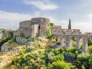 Old city. Sunny view of ruins of citadel in Stari Bar town near Bar city, Montenegro. Drone view Portrait of a disgruntled girl sitting at a cafe table