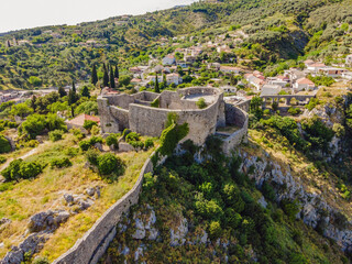 Fototapeta na wymiar Old city. Sunny view of ruins of citadel in Stari Bar town near Bar city, Montenegro. Drone view Portrait of a disgruntled girl sitting at a cafe table