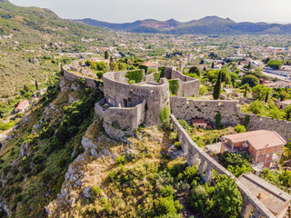 Fototapeta na wymiar Old city. Sunny view of ruins of citadel in Stari Bar town near Bar city, Montenegro. Drone view Portrait of a disgruntled girl sitting at a cafe table