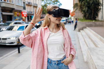 Young woman in VR glasses outdoors