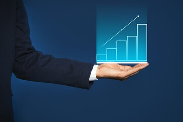 Salary increase concept. Man showing virtual image of charts and up arrow on blue background,...