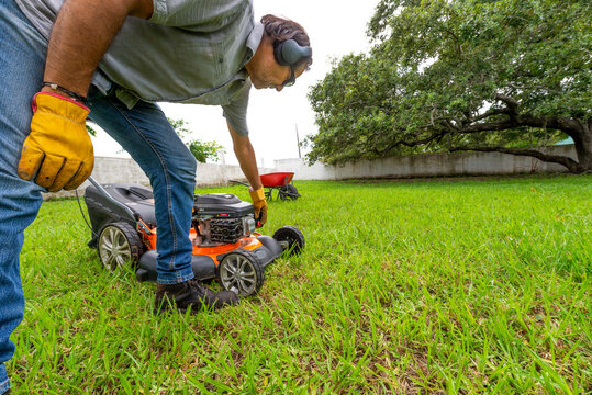 Hombre preparando podadora para trabajar en el jard&iacute;n de su casa