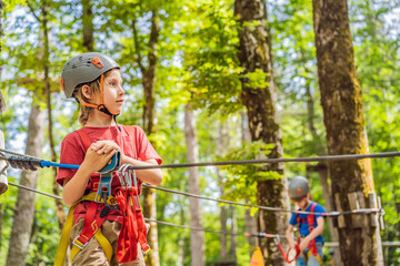 Happy child in a helmet, healthy teenager school boy enjoying activity in a climbing adventure park on a summer day Portrait of a disgruntled girl sitting at a cafe table