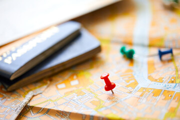 pins marking travel itinerary points on map and passport