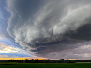 Obraz na płótnie Canvas A shelf cloud before a thunderstorm in farm country at sunset.