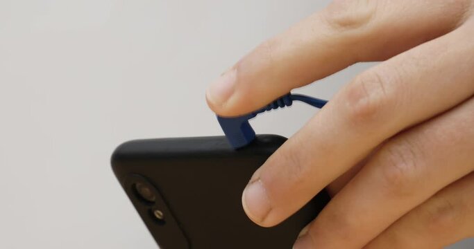 listening to music on the phone,hand insert headphones into smartphone High quality 4k footage