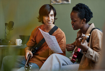 Minimal portrait of smiling young couple playing music together and composing songs