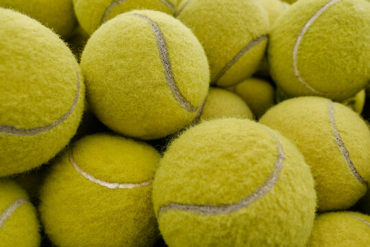 Bunch of yellow tennis balls, horizontal from above close-up shot, professional sport concept background