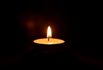 A simple white candle that shines in the dark, . 