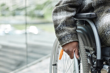 Naklejka premium Closeup of unrecognizable black woman in wheelchair pushing wheel, copy space