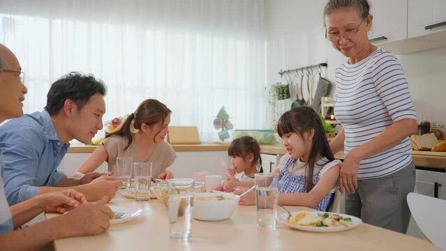 Asian big happy family have lunch on eating table together in house.	