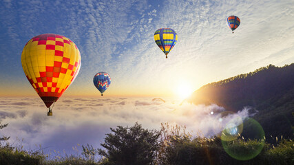 Hot air balloons flying over the clouds at sunset.