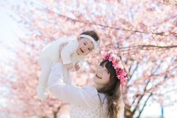 赤ちゃんとお母さん、桜の木の下で