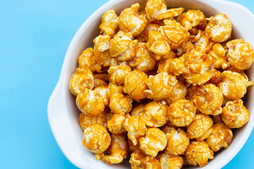 Honey caramel popcorn on blue background.