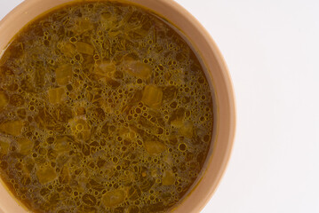 Soup in a plate on a white background. Closeup. Space for text