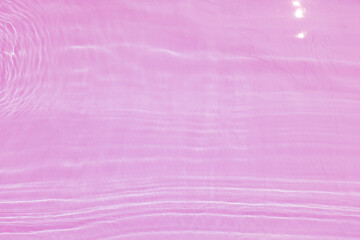 Defocus blurred transparent pink colored clear calm water surface texture with splash, bubble. Shining pink water ripple background. Surface of water in swimming pool. Pink bubble water shining.