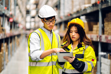 Asian two engineer team shipping order detail on tablet check goods and supplies on shelves with goods background inventory in factory warehouse.logistic industry and business export