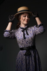 A beautiful woman in a romantic dress of the 19th century. Retro style, with a straw hat and lace...