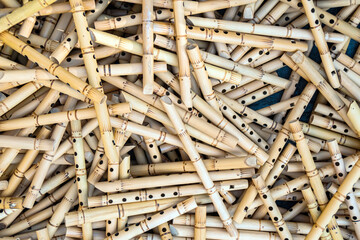 Pile of half-finished bamboo flutes, handmade bamboo flute production process by craftsmen, bamboo flutes being dried before finishing and marketed	