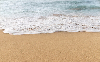 Fototapeta na wymiar Frothy Ocean Waves Washing Onto a Tropical Beach