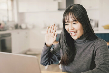 Obraz premium Young adult Asian woman working from home, distance learning, online teaching, video conference concept