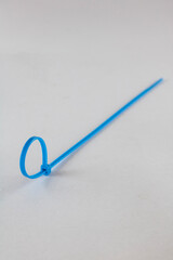 Blue plastic cable ties laid separately on a white background.