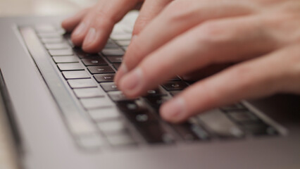 Close up macro of hands typing on laptop keyboard mac computer